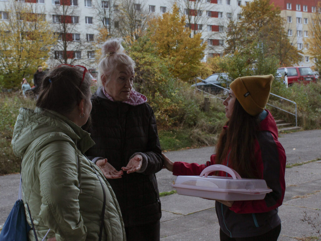 Nachbarinnen kommen bei einer Aktion für Nachbarschaft und Demokratie in Pirna ins Gespräch und bringen Kuchen mit.