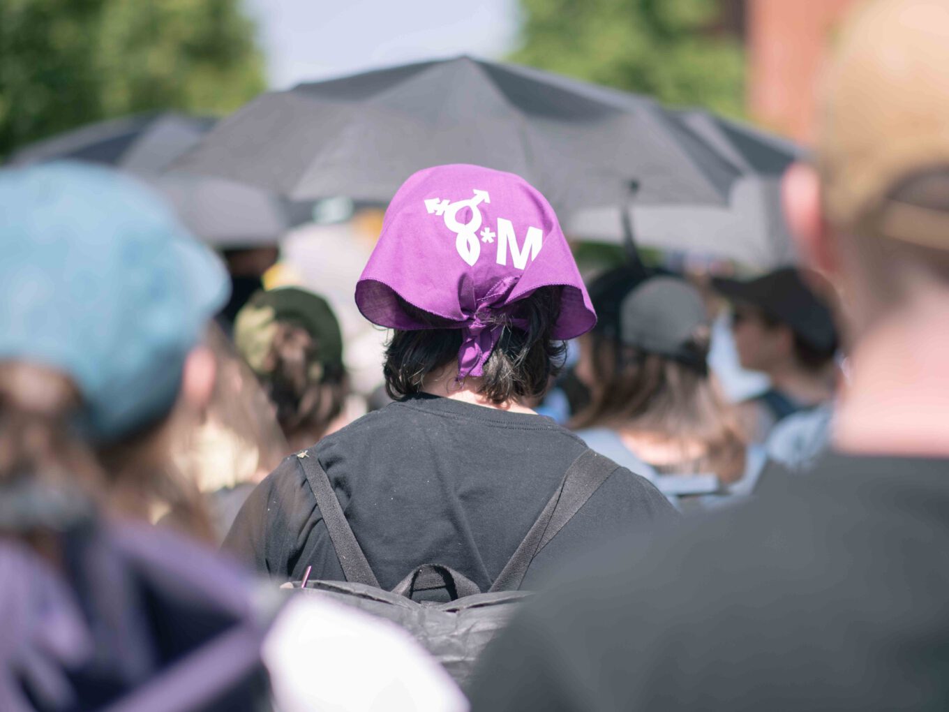 Person auf einer feministischen Demo mit 8. März-Tuch.